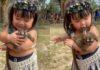 Menininha indígena nina filhote de macaco no colo e encanta