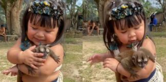 Menininha indígena nina filhote de macaco no colo e encanta